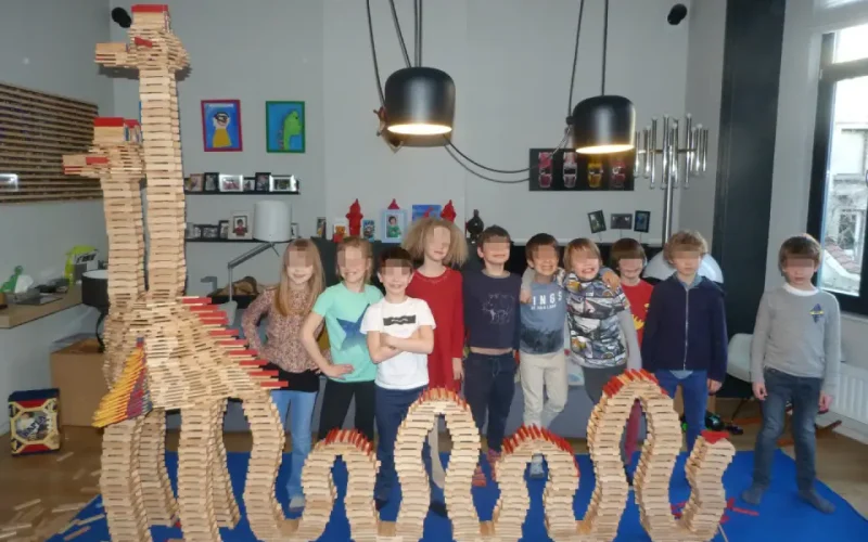 Centre Kapla de Bruxelles - kids standing in front of a building made of wooden blocks